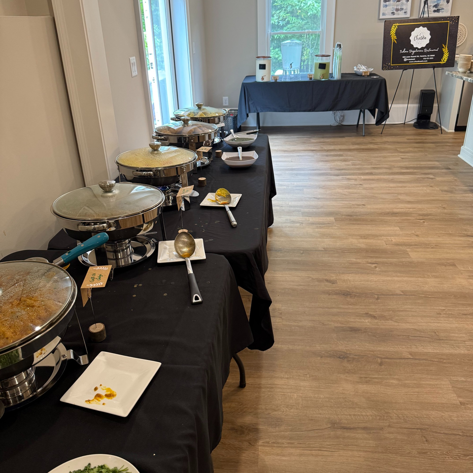 Chaska Indian vegetarian restaurant buffet setup with chafing dishes, serving utensils, and a welcome sign.
